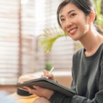 young-attrative-asian-female-working-home-hand-use-tablet-checking-businesss-data-chart-planning-report-with-leisure-relax-sofa-living-room-home-isolate-concept_609648-220